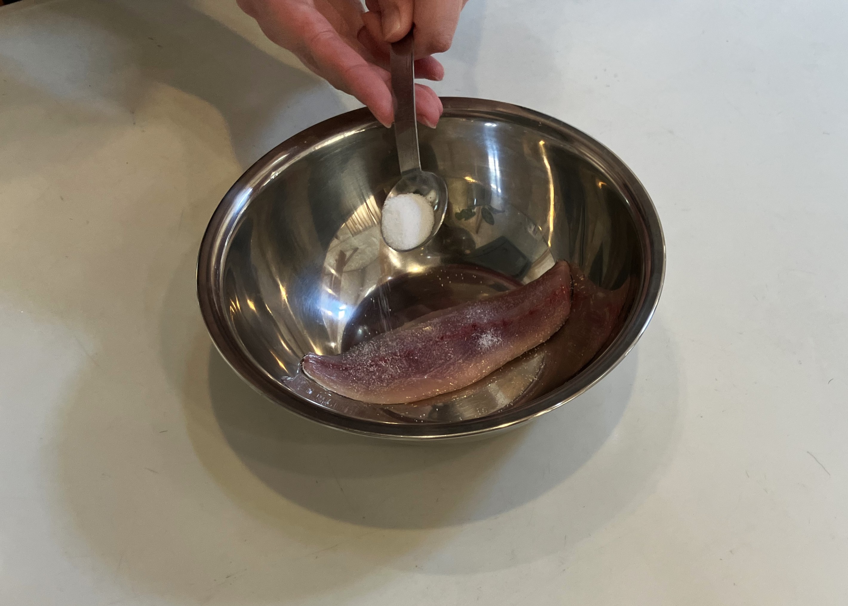 1. 魚の開きや切り身を塩水（5～10％濃度）につけるか、まんべんなく粗塩（魚の重さの2～3%の量)を振り、15～30分置きます