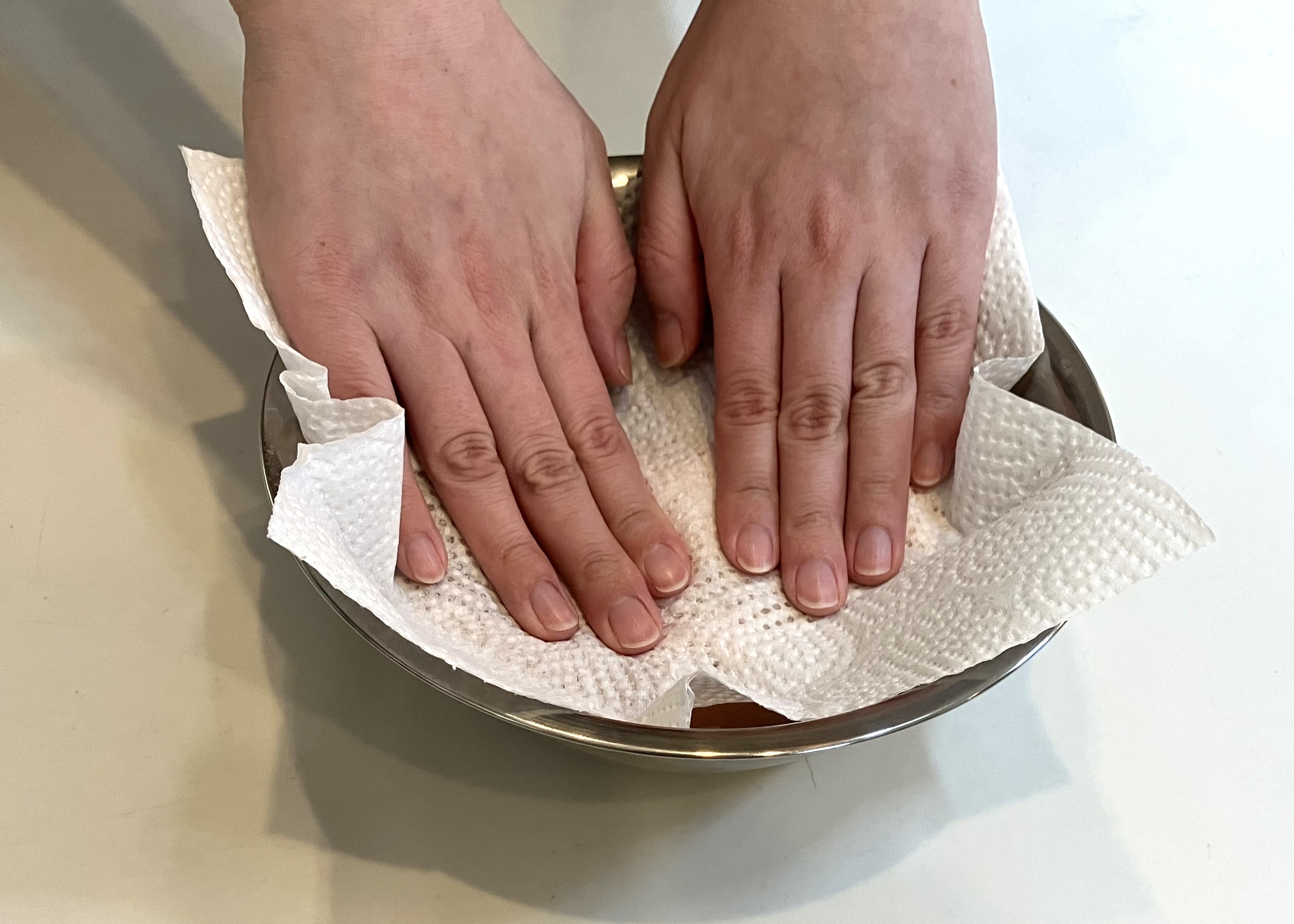 2. キッチンペーパーを皮に押し付けるようにして、皮をはがさないようにしながらしっかりと拭きます