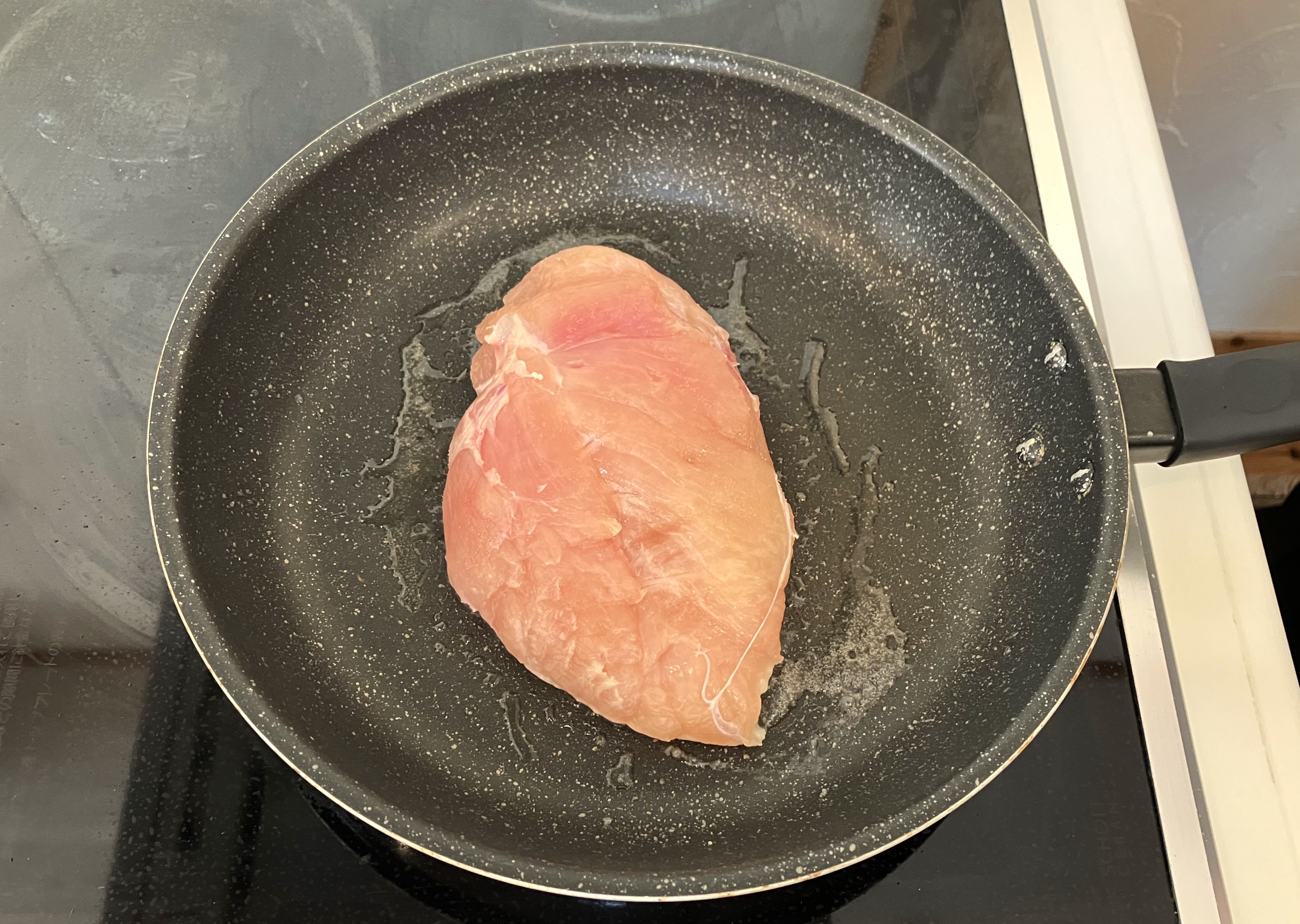 5. 熱したフライパンに油を敷き、味付けした鶏肉の皮側を下にして、フライ返しなどで押し付けながら焼いていきましょう