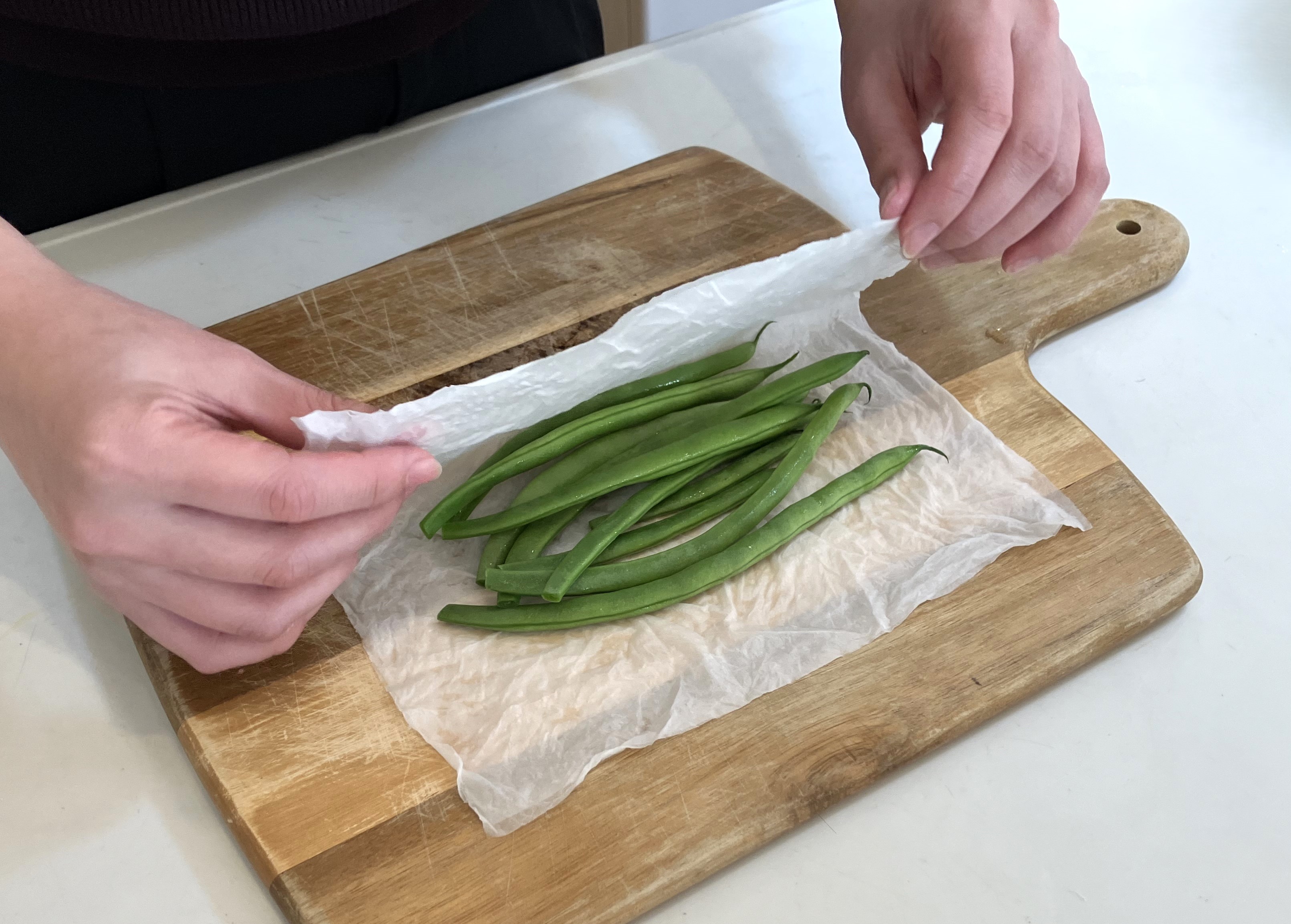 2. 絞ったキッチンペーパーでいんげんを包んでください