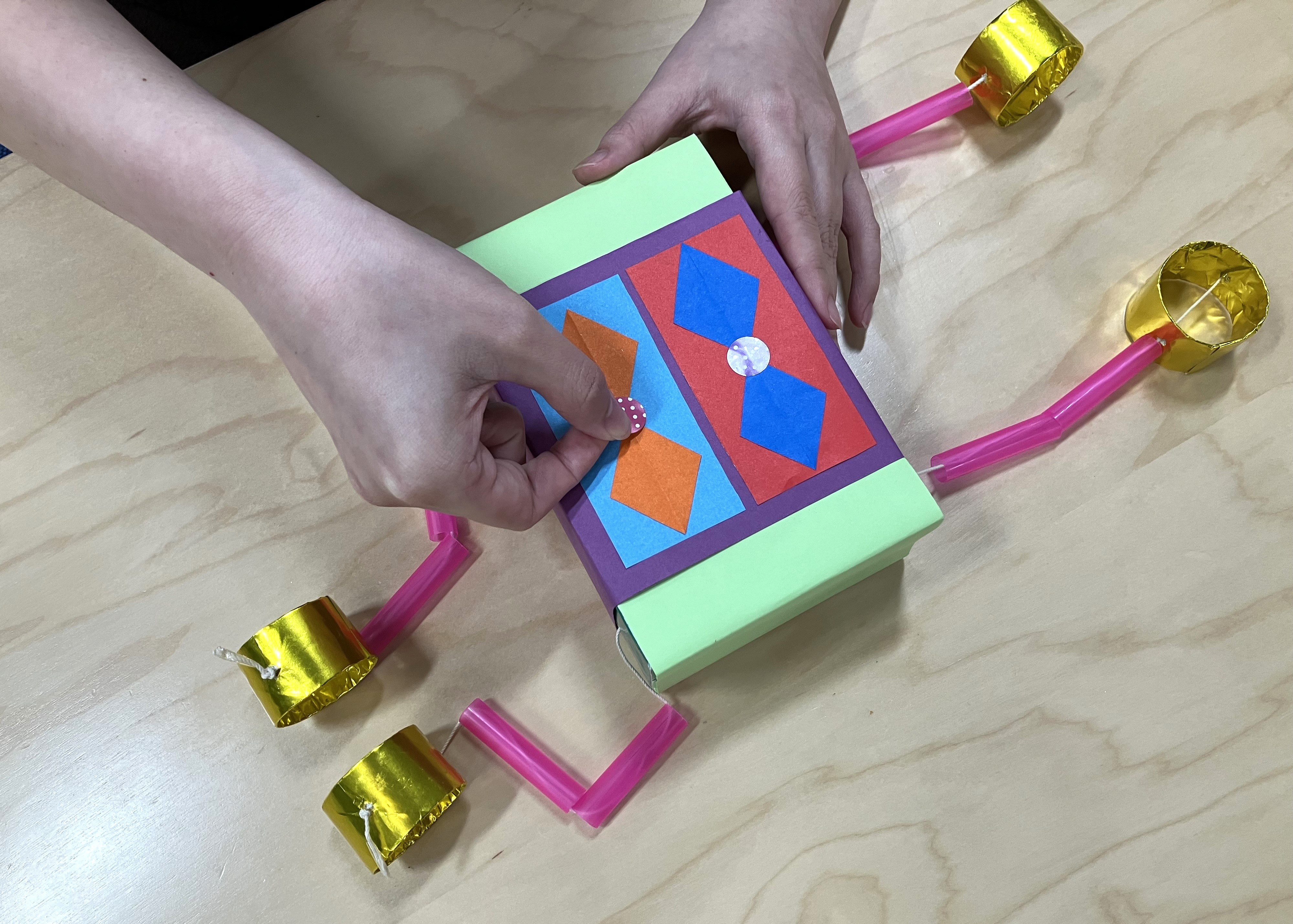 6. 手足をつけたティシューの箱を好きな長さになるように重ね、ティシューの取り出し口からステープラーでとめたら胴体の完成