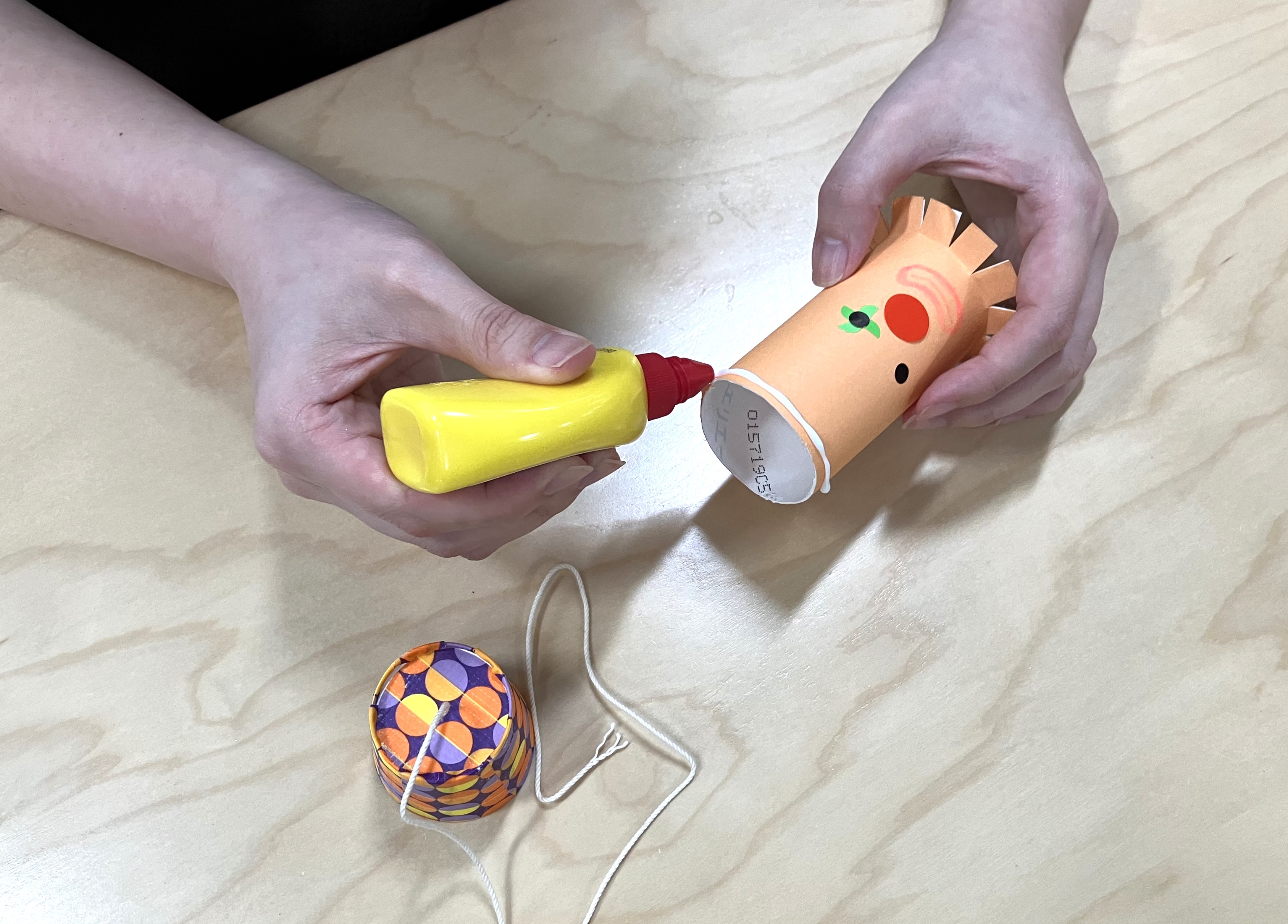 10. 帽子ができたら、7～8で作った顔パーツの上部に木工用ボンドを塗り、帽子をかぶせて接着します