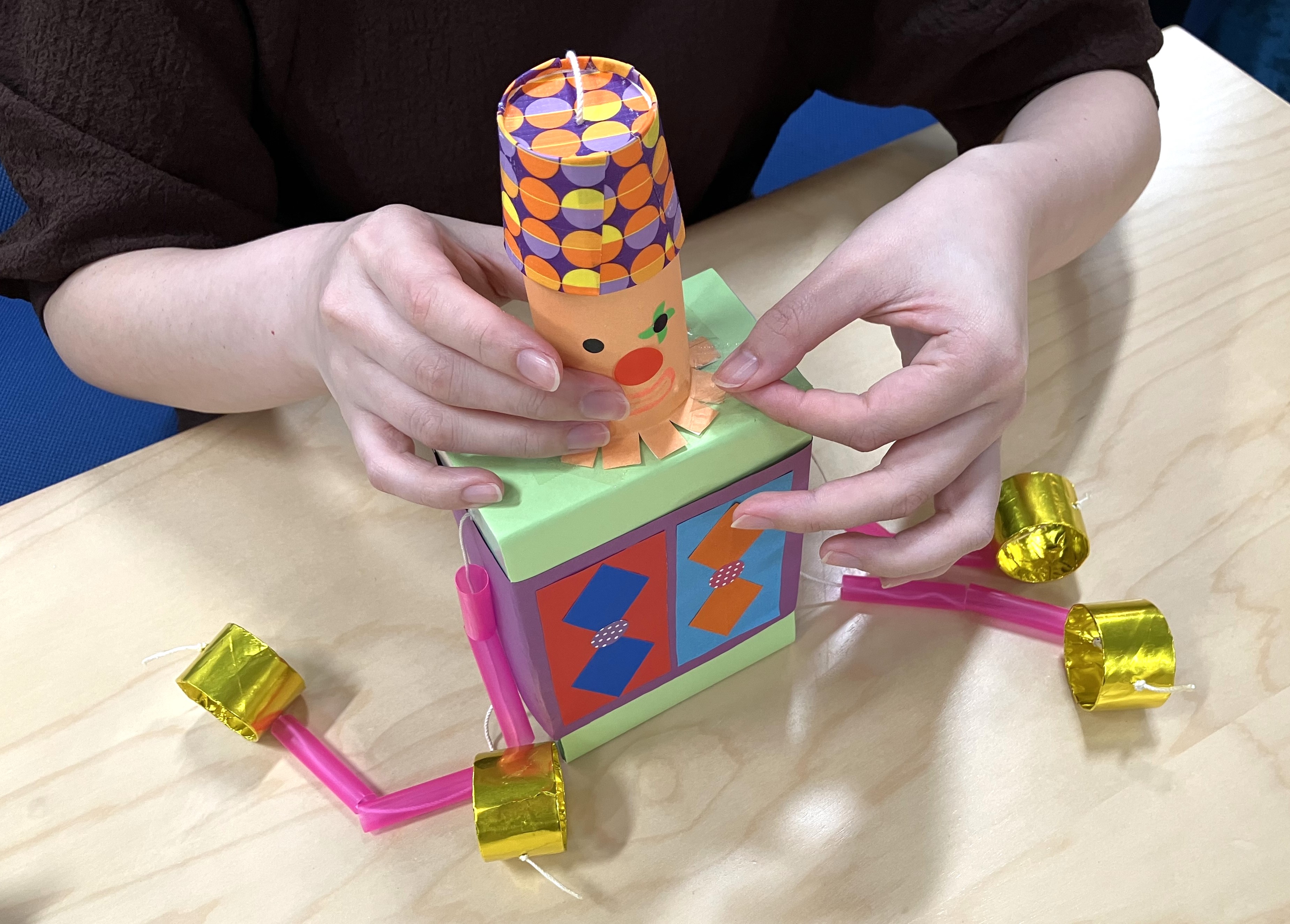 11. 胴体の上に、10で作った顔と帽子をセロハンテープでとめます