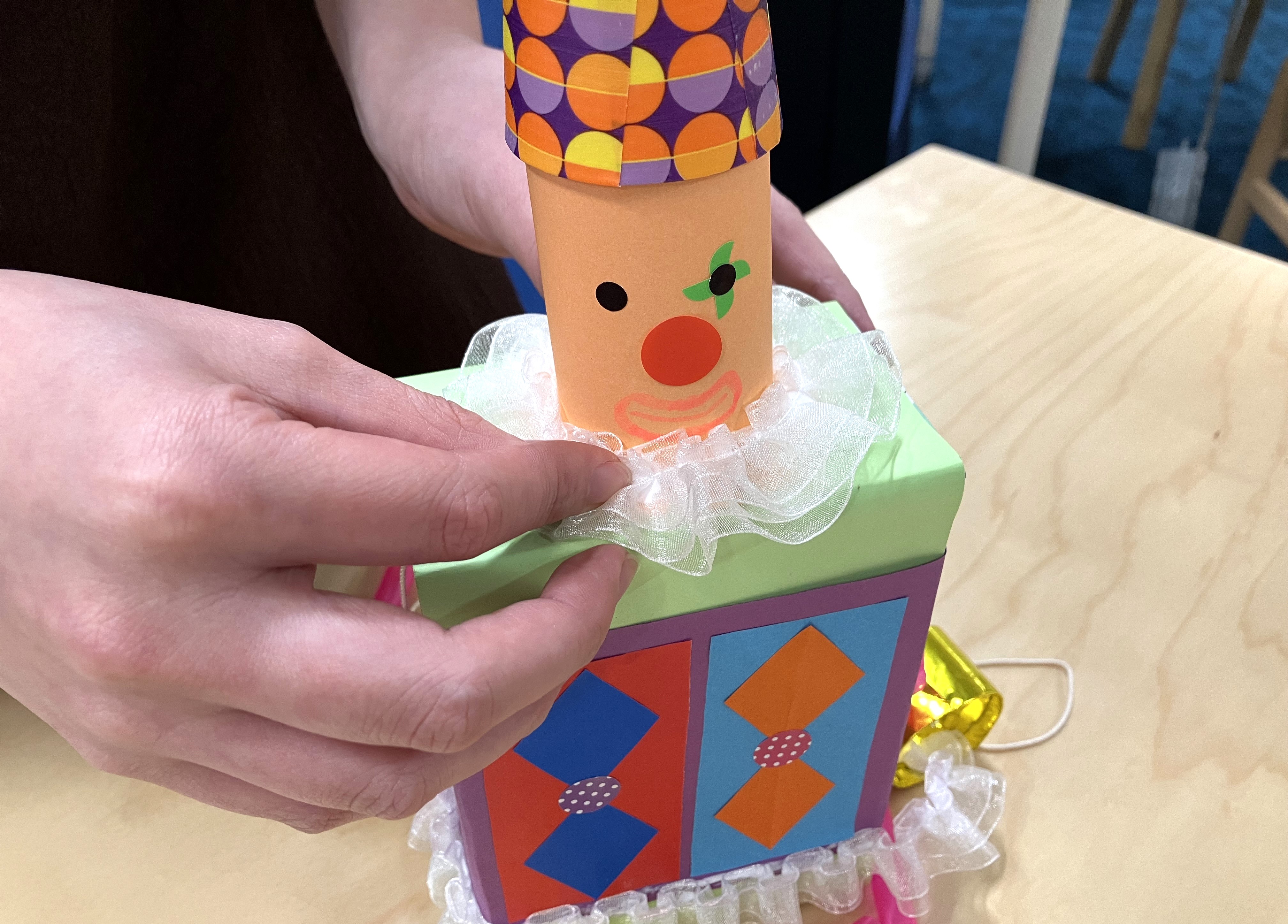 11. 胴体の上に、10で作った顔と帽子をセロハンテープでとめます